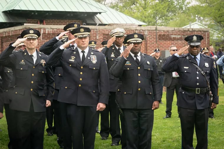 Officers salute at a memorial service honoring fallen police officers and firefighters. While the city studies ways to reemployee retirees amid a chronic staff shortage, retired officers and their survivors say inflation is chipping away at pensions.