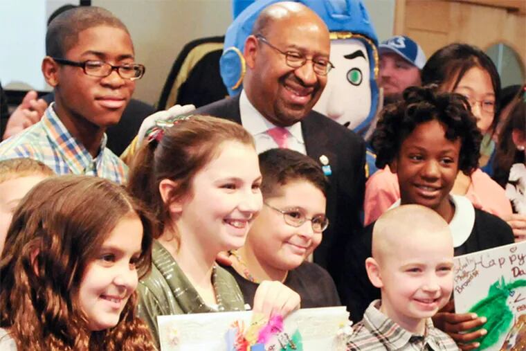 Mayor Nutter poses with young artist and winners of the Parks and Recreation's Kids Mummers Poster contest during a press conferences at the Independence Visitors Center to annound plans for the 2014 Mummers Parade. ( RON TARVER / Staff Photographer )