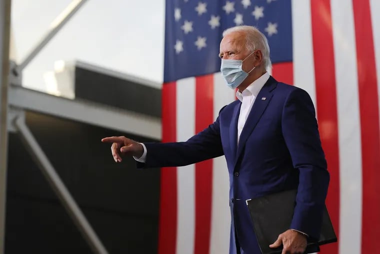Wearing a face mask to reduce the risk posed by the coronavirus, Democratic presidential nominee Joe Biden points to supporters during a drive-in voter mobilization event at Miramar Regional Park Oct. 13, 2020 in Miramar, Florida. With three weeks until Election Day, Biden is campaigning in Florida.