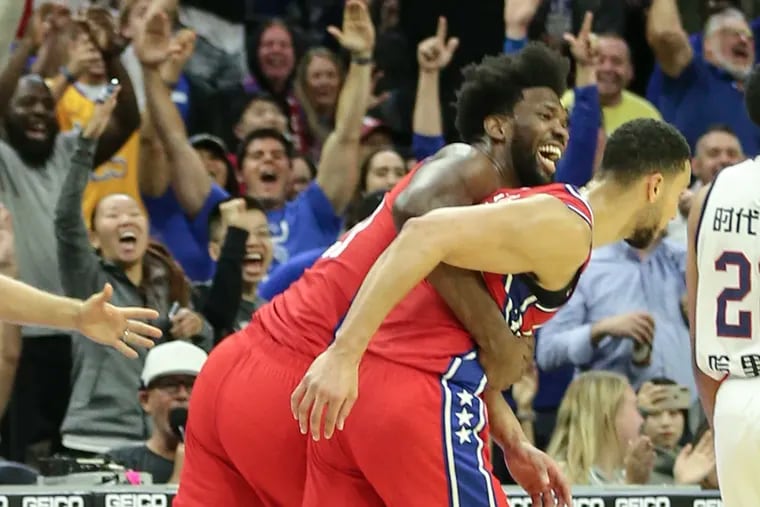 Sixers' Joel Embiid hugs Ben Simmons after his three pointer against the Guangzhou Loong-Lions during the end of the 2nd quarter of a pre-season game at the Wells Fargo Center in Philadelphia, Tuesday, October  8, 2019.