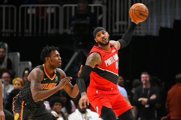 Carmelo Anthony keeping the ball away from Atlanta Hawks guard Treveon Graham during a February game.