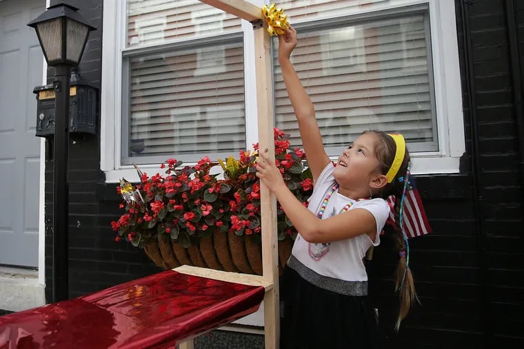 Alviia Whitaker, 7, decorates her lemonade stand in preparation for her Saturday sale.