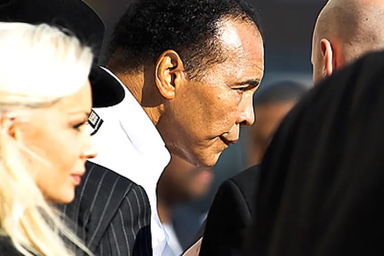 Boxing great Muhammad Ali, center, leaves the funeral for Joe Frazier.  (David Maialetti/Staff Photographer)