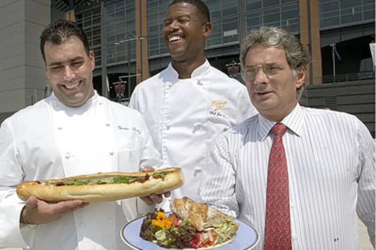 Georges Perrier (right) once created a lobster hoagie at Lincoln Financial Field. So why not a cheeseburger for Le Bec-Fin?  Also pictured: Chefs Gene Betz, left, and Joe Brown, center, in 2003. (Peter Tobia / Staff Photographer)