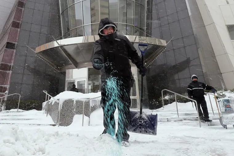 An employee spreads ice melt at a Bally's entrance on in Atlantic City in January.