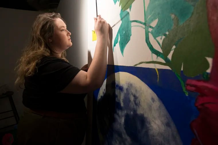 Meg Wolensky works on "Winged Victory (Work in Progress)" on Sept. 5, 2019. It is one of ten temporary art murals by local artists for a new project, Streets Dept Walls, on display in the Fashion District.
