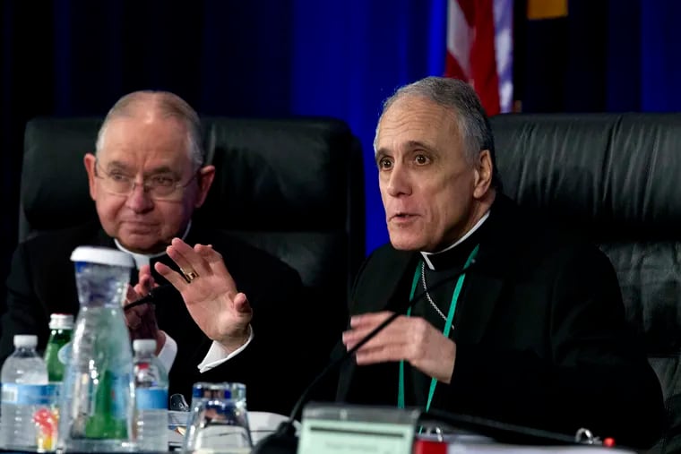 Cardinal Daniel DiNardo of the Archdiocese of Galveston-Houston (right), president of the U.S. Conference of Catholic Bishops, accompanied by Jose Gomez, archbishop of Los Angeles, speaks to the bishops before the morning prayer at the organization's spring meeting in Baltimore on Tuesday, June 11, 2019.