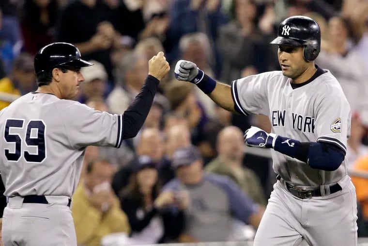 Derek Jeter (right) getting congratulated by third-base coach Rob Thomson after hitting a home run during a 2009 game.