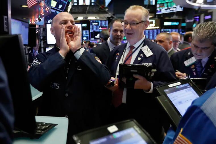 In this Thursday, Nov. 29, 2018, photo, specialist John O'Hara, left, works with traders at his post on the floor of the New York Stock Exchange. The new cease-fire in the trade dispute between the U.S. and China should boost rattled financial markets, at least likely through year's end. But the stock market's wild gyrations of recent months likely will persist as the two countries strain to reach a permanent accord in the next three months, some experts say. (AP Photo/Richard Drew)
