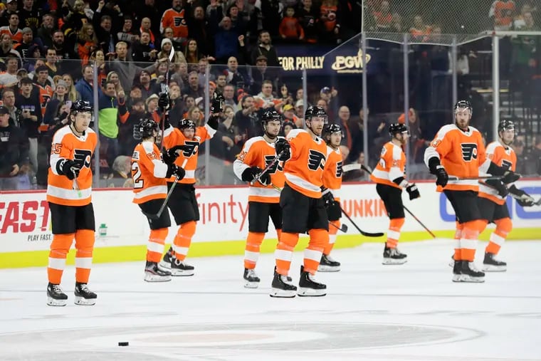 Flyers players point to the puck after Boston Bruins left winger Brad Marchand missed it during a shootout attempt on Monday. It was one of the more bizarre endings to a game you'll ever see.