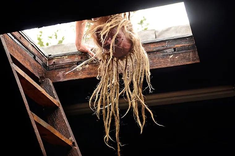 Willow Zef  (real name: Jozef Maguire) looks into the attic, from the widow's walk on the roof of the Knight Park house in Collingswood Sept. 26, 2013, where he lives as resident curator, renovator, handyman and poet.  ( TOM GRALISH / Staff Photographer )