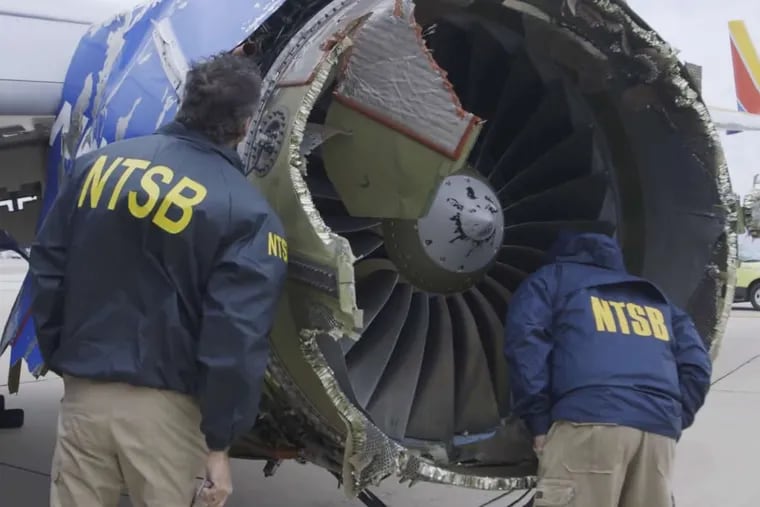 In a frame from video, a National Transportation Safety Board investigator examines damage to the engine of the Southwest Airlines plane that made an emergency landing at Philadelphia International Airport.