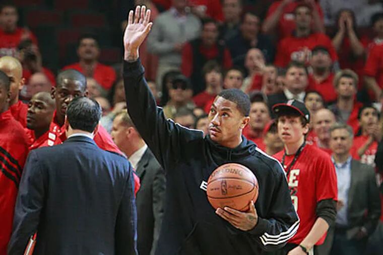 Derrick Rose hobbled to mid-court to present the honorary game ball at the start of Game 2. (Ron Cortes/Staff Photographer)