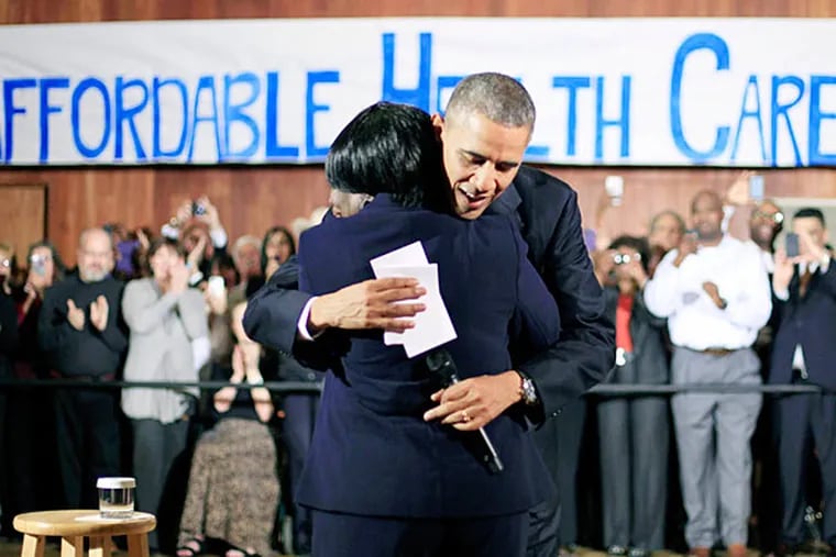 President Barack Obama hugs Edna Pemberton, who introduced him, before speaking with volunteers who helped people enroll through the HealthCare.gov site at Temple Emanu-El on Wednesday, Nov. 6, 2013, in Dallas. (Associated Press)