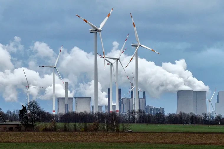Renewable and fossil-fuel energy is produced when wind generators are seen in front of a coal fired power plant near Jackerath, Germany, Friday, Dec. 7, 2018. (AP Photo/Martin Meissner)