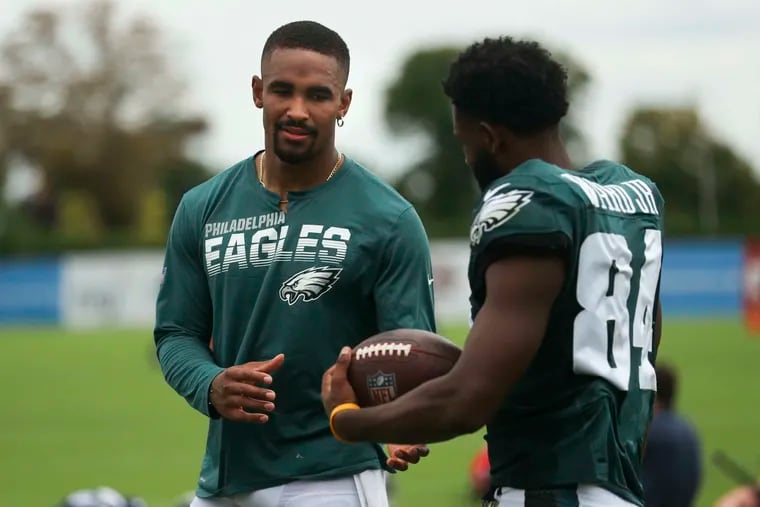 Eagles quarterback Jalen Hurts (left) and receiver Greg Ward talk after a joint practice with the New England Patriots in the summer.
