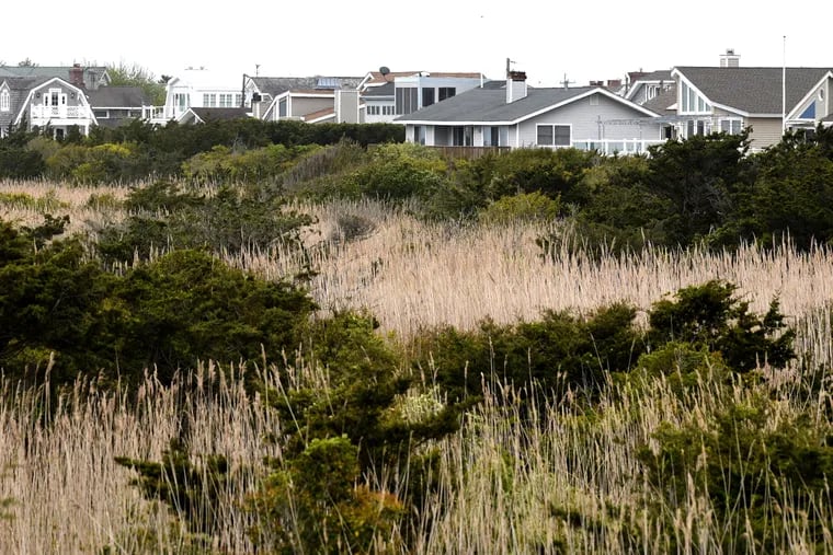 Shore homes are photographed behind the beach dunes on the Jersey Shore. Twelve people from Bucks County contracted the coronavirus over the past two weeks from a visit to the Shore.
