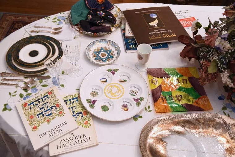 The Passover Seder table in the dining room of the Judaica-filled home of Phyllis and Michael Levy. There are many Haggadot (Passover prayer books), including a Russian version of their favorite (left- with Leonard Baskin drawings) from when they hosted a family from the former Soviet Union. Also a seder plate (center) from Phyllis&#039; mother and a serving plate (right) from Michael&#039;s Bubbe - grandmother, Bubbe - grandmother - given to the couple as an engagement present (it is usually used for the brisket).