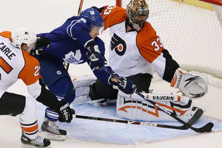 Toronto Maple Leafs' Niklas Hagman, center, skates past Philadelphia Flyers defenceman Matt Carle, left, only to be stopped by Flyers goaltender Brian Boucher during an NHL preseason hockey game in Toronto on Saturday, Sept. 19, 2009. (AP Photo/The Canadian Press,Darren Calabrese)