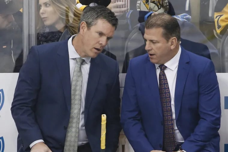 Penguins head coach Mike Sullivan, left, and assistant Mark Recchi talk behind the bench during a game against Buffalo.