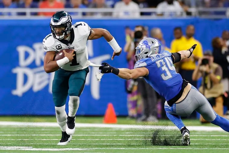 Eagles quarterback Jalen Hurts runs past Detroit Lions linebacker Alex Anzalone during the second quarter on Sunday.