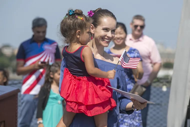 Forty seven candidates from thirty-three countries became naturalized US citizens in 2017 after taking the Oath of Allegiance on board the battleship New Jersey in Camden. Here, carrying her 3 year old daughter, Olivia, Polish-born Hanna Pawlowska smiles after receiving her citizenship. 