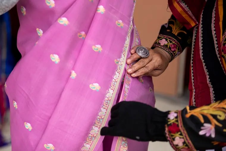 (right) Geetha Ganju, of Chalfont, drapes a saree for Michelle Atkinson, of Furlong, before the first Saree Run at Doylestown Central Park in Doylestown, Pa. on Sunday, March 27, 2022.  
