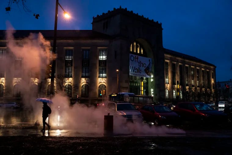 A pedestrian walks past the Perelman Building of the Philadelphia Museum of Art as rain falls during a recent evening commute.