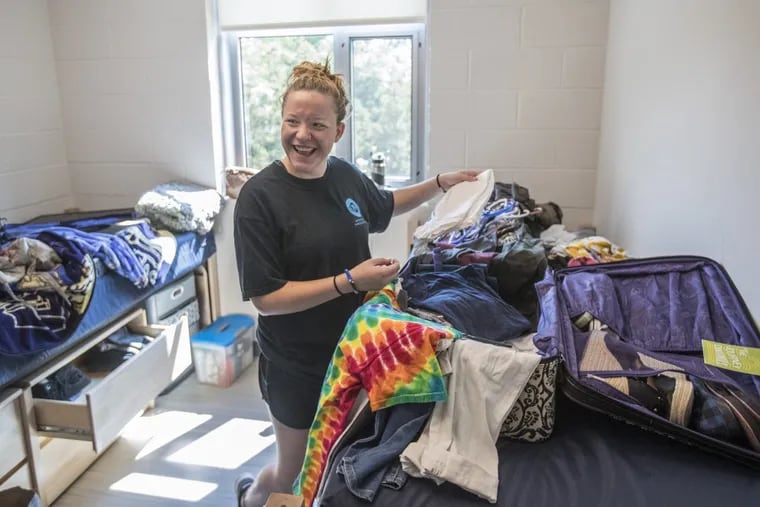 Michaela Everett from Tucson, Ariz., shares a laugh with her mother as she unpacks her clothes in her new dorm room at Penn State Abington on Wednesday.