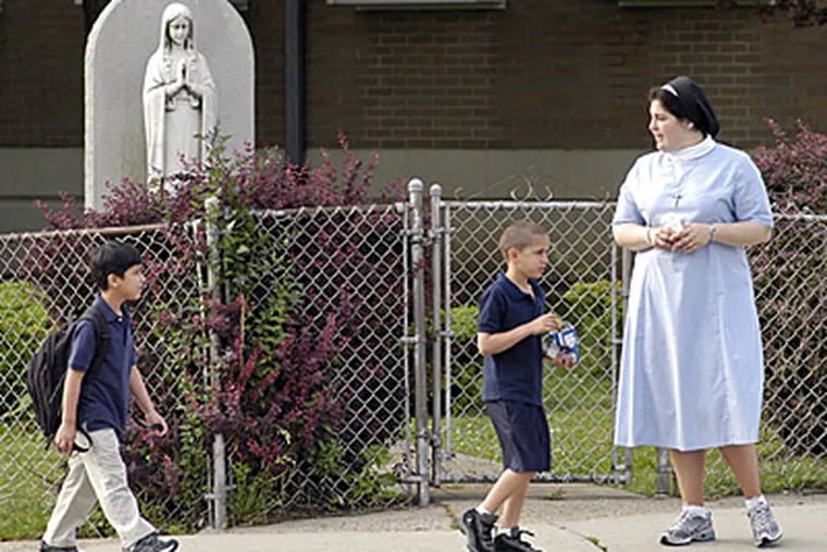 Holy Innocents Catholic School 8th grade teacher Sister Danielle Therese  informs students arriving at the school today that classes were canceled after a double shooting in the parking lot.  (Tom Gralish / Inquirer)
