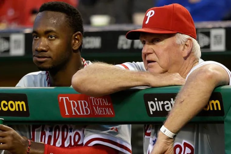 Domonic Brown (left) stands in the dugout with Charlie Manuel during the eighth inning of a baseball game in Pittsburgh Wednesday, July 3, 2013. (Gene J. Puskar/AP)