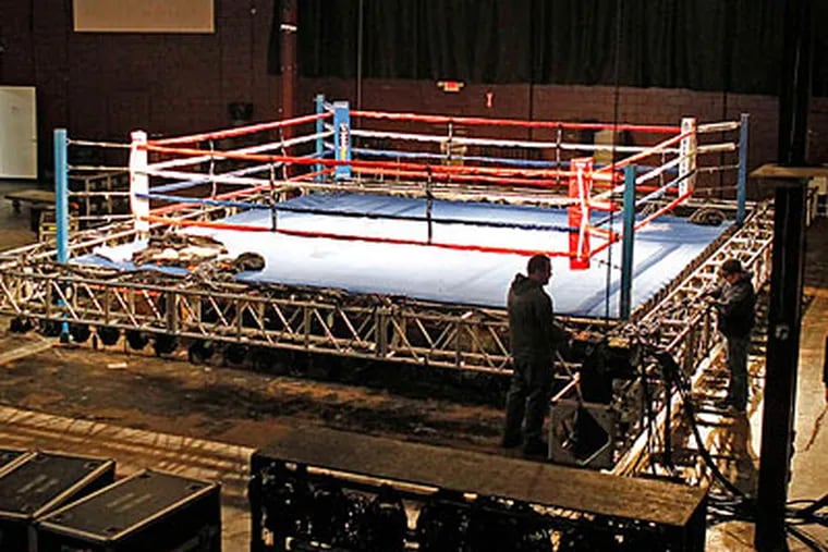 Workers set up for the premiere of "Fight Night" on the NBC Sports Network. (Akira Suwa/Staff Photographer)