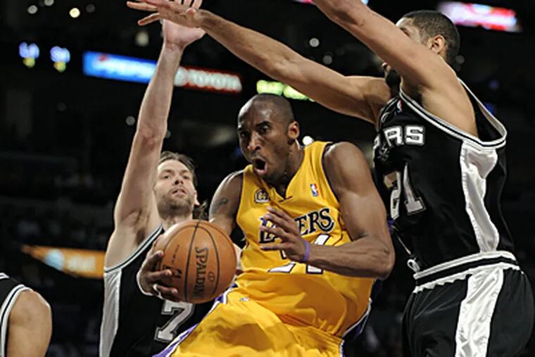 Los Angeles Lakers' Kobe Bryant, center, drives to the basket between San Antonio Spurs' Fabricio Oberto, left, of Argentina, and Tim Duncan during the first half in Game 2 of the NBA
Western Conference basketball finals, Friday, May 23, 2008 in Los Angeles. (AP Photo/Mark J. Terrill)