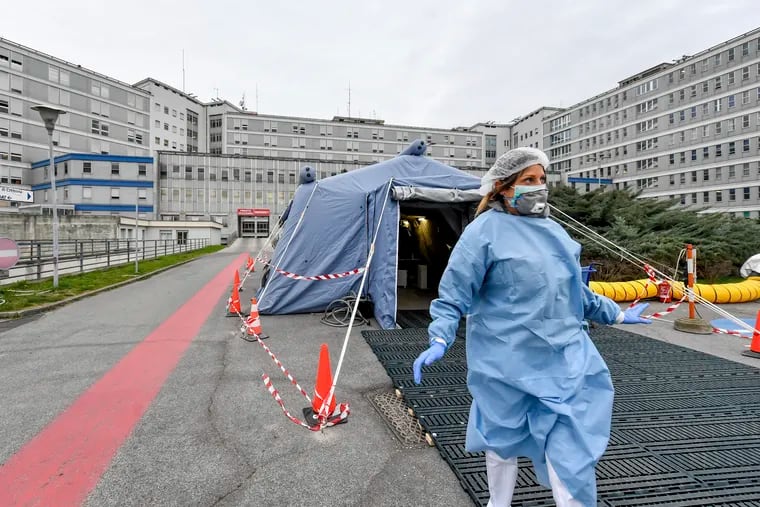 A paramedic leaves a tent in front of the emergency ward of the Cremona hospital, northern Italy. The coronavirus spread so fast in that country that doctors spoke of choices war-time triage medics make in deciding who lives and who dies, and who get access to the limited number of ICU beds.