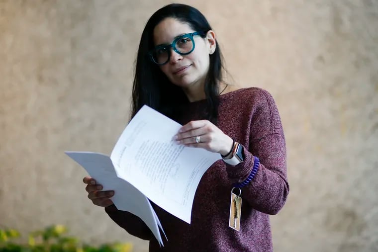 Irene Contreras holds a copy of her parents medical prescriptions in the lobby of her Center City office building. A month-long process is required to get the prescription from Venezuela to Philadelphia to Canada and back again.