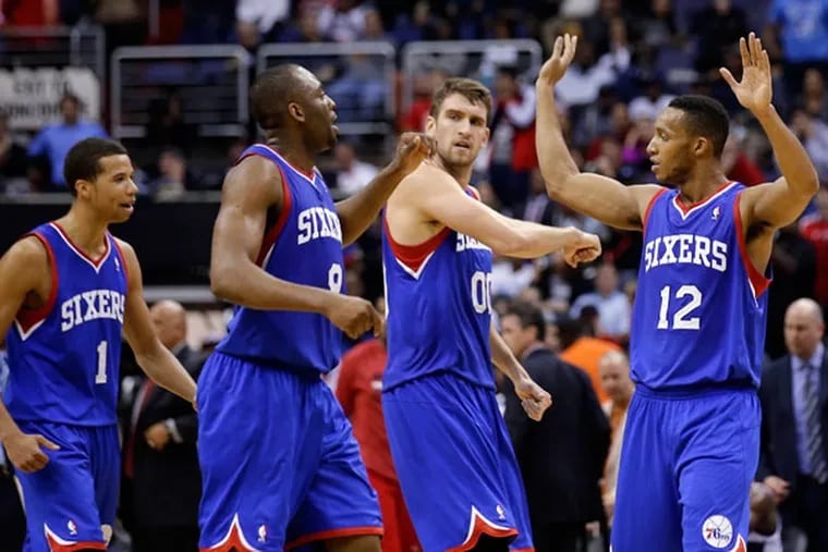 76ers guard Michael Carter-Williams (1), guard James Anderson (9), center Spencer Hawes (00), and forward Evan Turner (12) celebrate in the second half of an NBA basketball game against the Washington Wizards, Friday, Nov. 1, 2013, in Washington. The 76ers won 109-102. (Alex Brandon/AP)