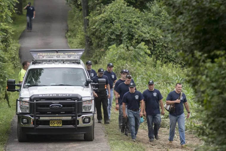 Cadets with Montgomery County Community College Municipal Police Academy take a break in the search for clues in the disappearance of four Bucks County men, Tuesday.