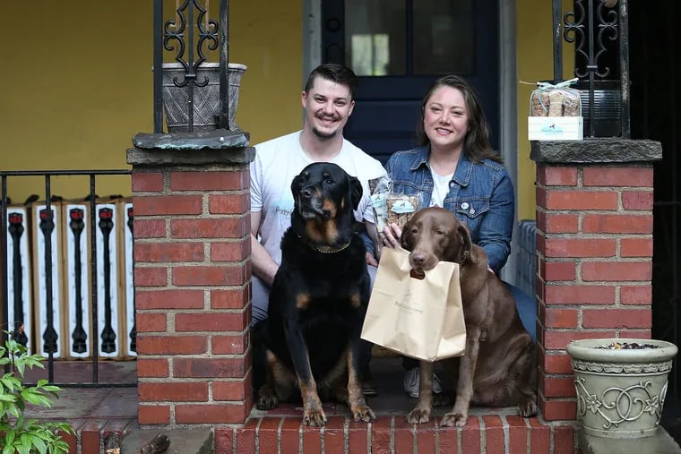 Chris Courter and Jennifer Kirby, who own and operate Piggyback Treats Company, with their dogs — Atlas (left) and Candy.