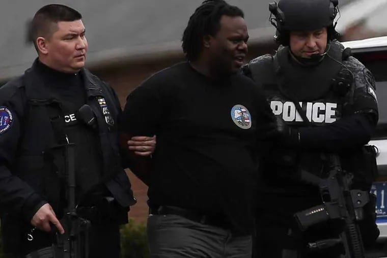 Police take a man into custody after hostages were release from  the La Mott Fire Company firehouse on March 31, 2015, in Cheltenham Township. ( Joseph Kaczmarek / For the Inquirer and Daily News )
