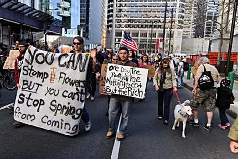 Occupy Philadelphia demonstrators march along Market Street on their way from Rittenhouse Square to Independence Mall, where they planned a weekend encampment. RON TARVER / Staff Photographer