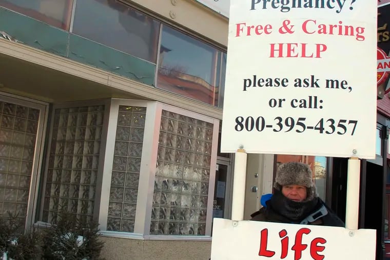 FILE - In this Feb. 20, 2013, file photo, an abortion protester stands outside the Red River Valley Women's Clinic in Fargo, N.D. North Dakota's sole abortion clinic filed a federal lawsuit Tuesday, June, 24, 2019, over two state laws it believes forces doctors to lie, including one measure passed this year requiring physicians to tell women that they may reverse a so-called medication abortion if they have second thoughts.
