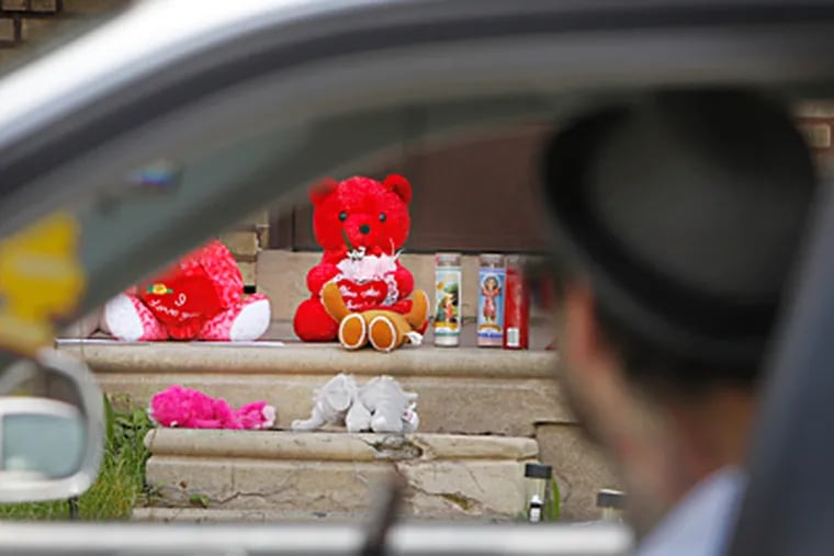 A motorist passes a makeshift memorial on the 3600 block of Ditman Street in the Tacony section of Philadelphia, where a woman allegedly killed her twin children Thursday. ALEJANDRO A. ALVAREZ / Staff Photographer