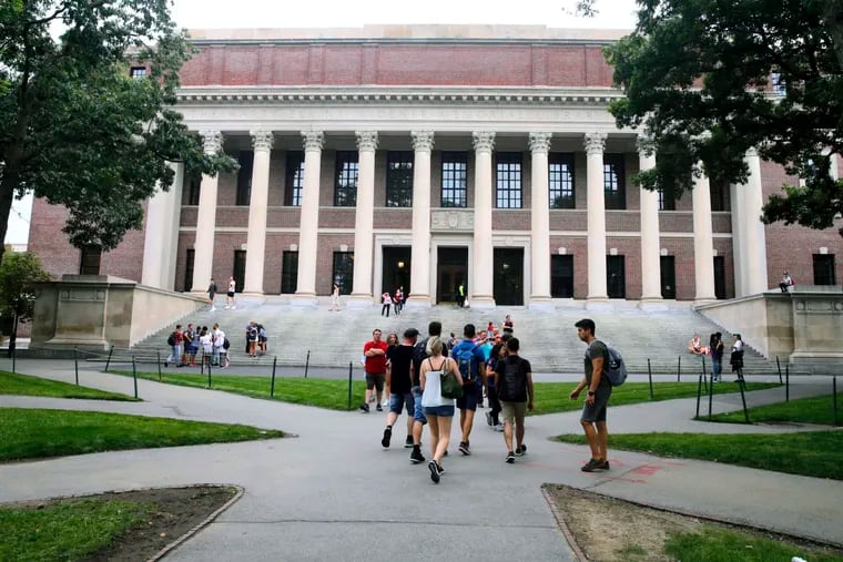 Students walk near the Widener Library at Harvard University in Cambridge, Mass.