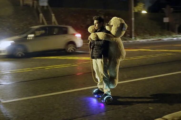 Riding a hoverboard with a big bear on his back, 19-year-old JR Lara of Bellmawr heads south on the Black Horse Pike just after 12:30 am on November 30, 2016.