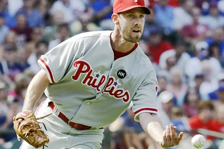 Cliff Lee tosses a ground ball by Chicago Cubs' Ryan Theriot to first baseman Ryan Howard during the seventh inning of the Phillies' 6-1 win today. (AP Photo/Charles Rex Arbogast)