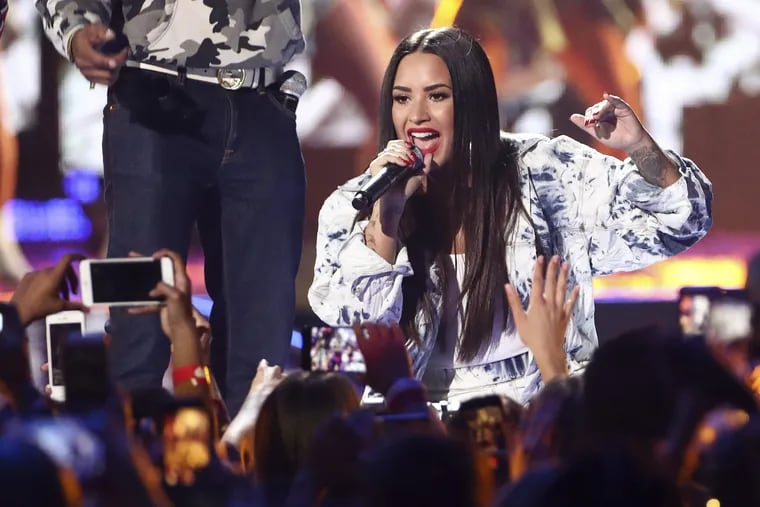 In this Sept. 23, 2017 file photo, Demi Lovato performs at the 2017 iHeartRadio Music Festival in Las Vegas. Emergency officials confirm Tuesday, July 24, 2018, they transported a 25-year-old woman who lives on Demi Lovato's block to the hospital amid reports that the pop star suffered a drug overdose.