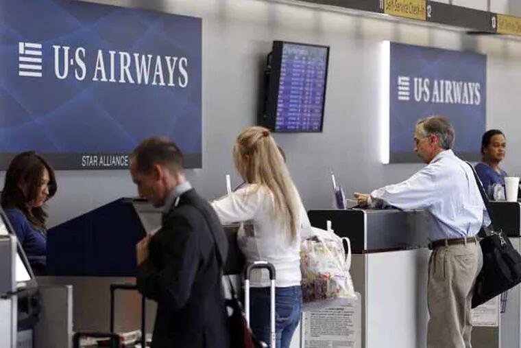 FILE - In this Sept. 27, 2012 file photo, US Airways employees assist customers at a ticket counter at the Charlotte/Douglas International airport in Charlotte, N.C. The merger of US Airways and American Airlines has given birth to a mega airline with more passengers than any other in the world and a whopping eight hubs around the United States, leading industry analysts to wonder which of those airports will emerge as winners of losers. (AP Photo/Chuck Burton, File)