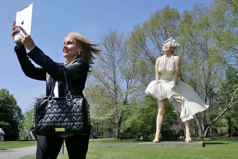 Johanna Bianchi of Freehold, N.J., took a photo of herself Sunday with the larger-than-life Marilyn Monroe. (Mel Evans / AP)
