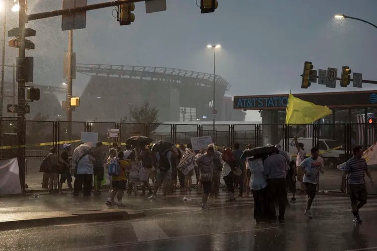 Heavy rains don't deter protesters outside the Wells Fargo Center.