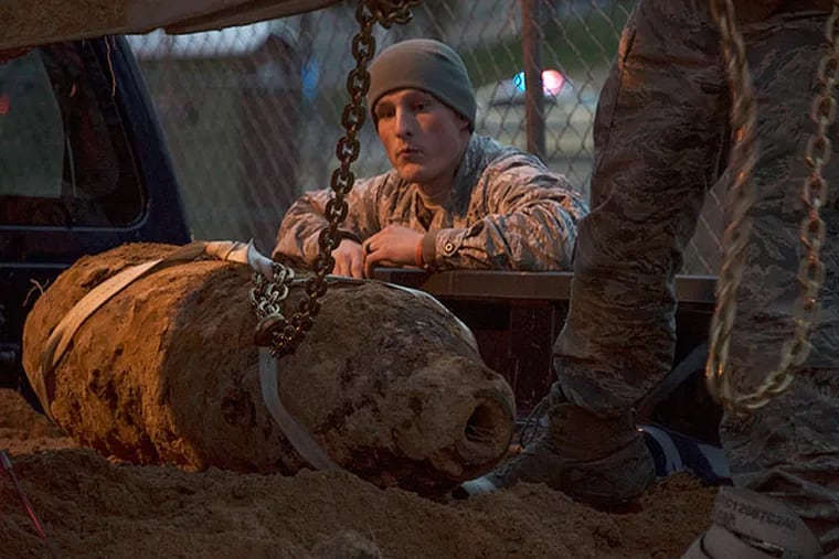Airman First Class Dylan Graham offers guidance during removal of the 500-pound bomb. (U.S. Air Force)
